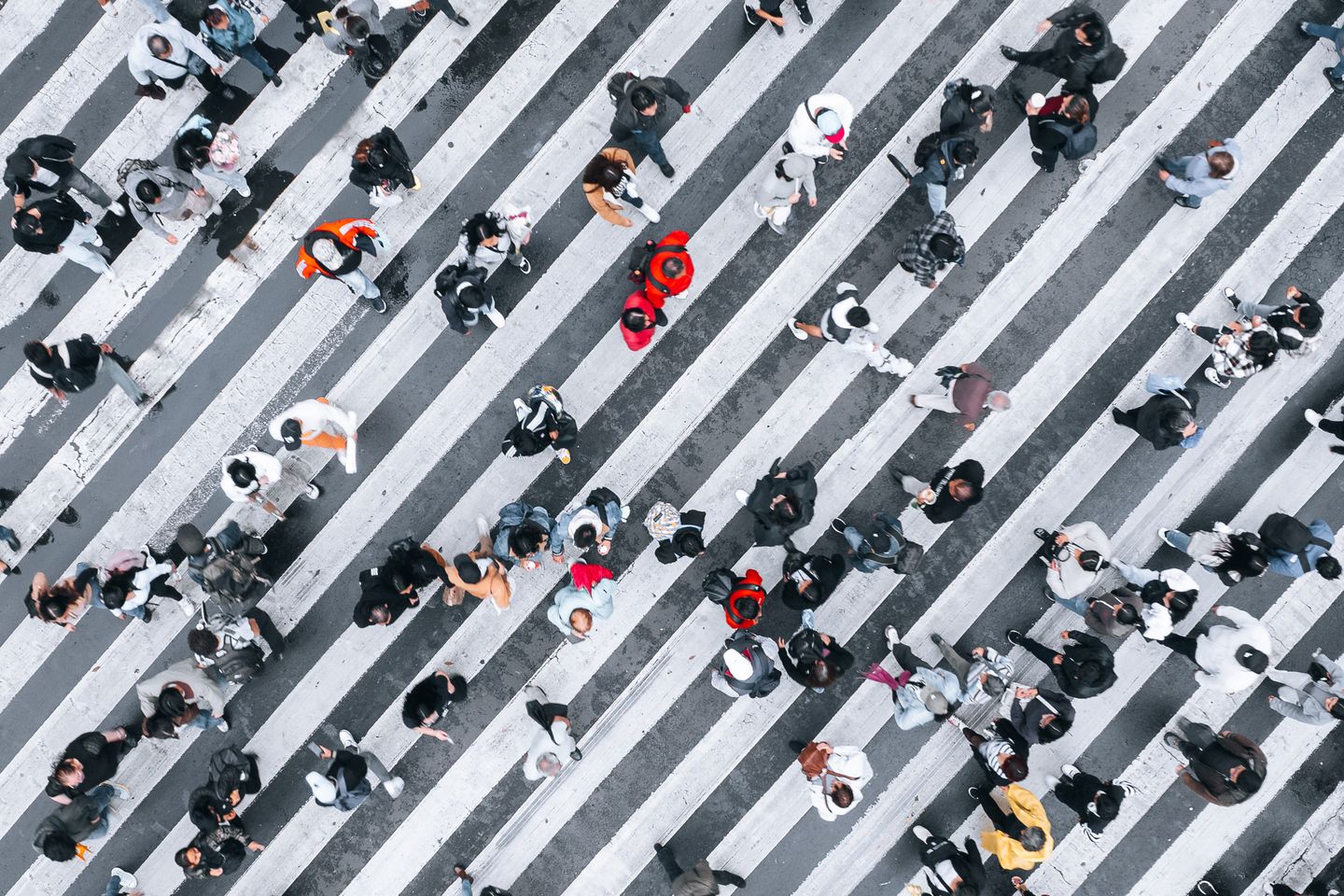 Aerial view of pedestrians crossing a marked crosswalk.