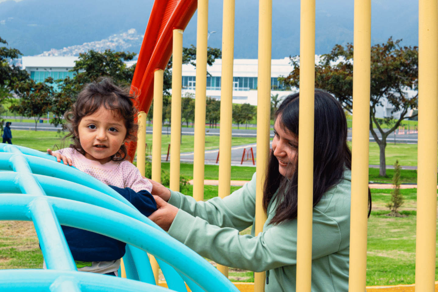 Mujer latinoamericana cuidando a su hija en un parque público