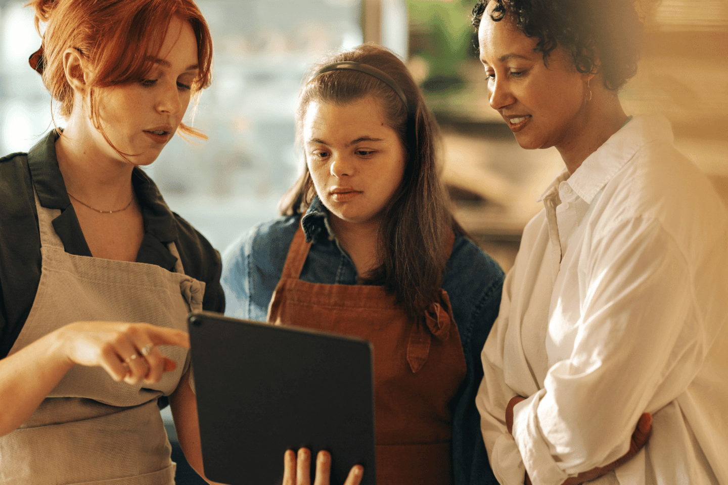 Joven con síndrome de Down trabaja con dos compañeras