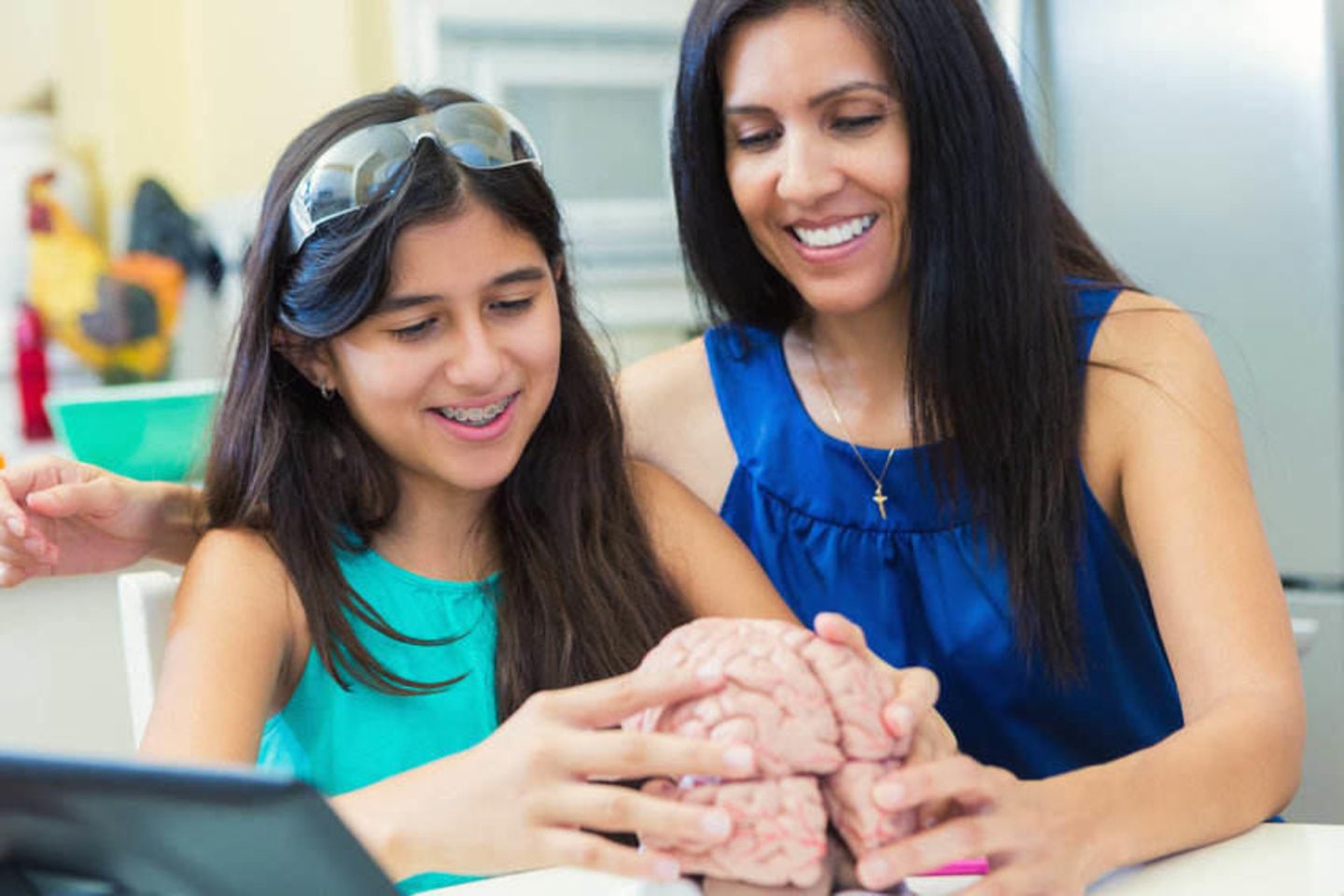 Mature mother teaching her preteen daughter during homeschool science class