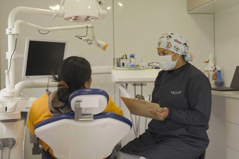 Mujer sentada en sillón dental siendo atendida por odontóloga. Salud e inclusión - Banco Interamericano de Desarrollo - BID 