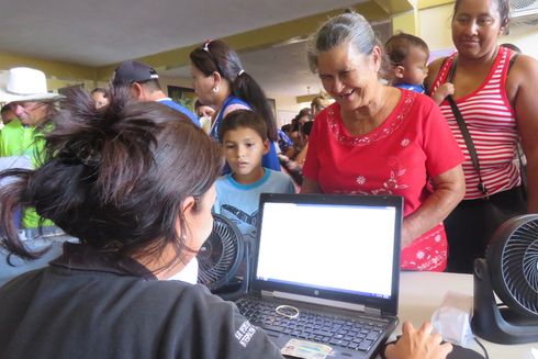 Mujeres y niños siendo atendidos por una funcionaria pública. Modernización del Estado - Banco Interamericano de Desarrollo 