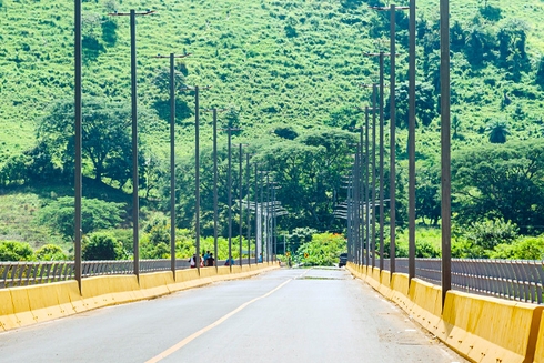 Vista de vía de un puente con montaña verde de fondo. Desarrollo rural y económico - Banco Interamericano de Desarrollo - BID 