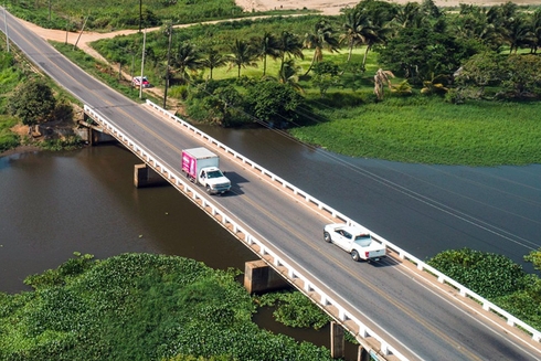 Vehículos transitando un puente que pasa sobre un río. Transporte y Desarrollo - Banco Interamericano de Desarrollo - BID