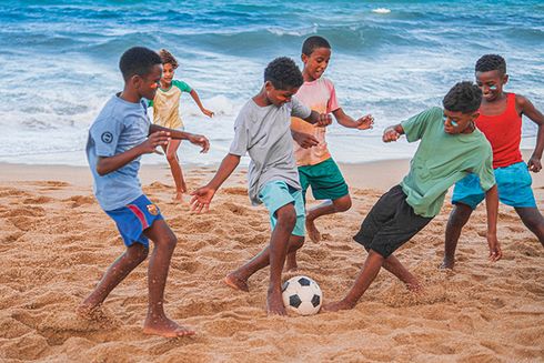 Niños jugando con balón de fútbol en la playa. Desarrollo social e inclusión - Banco Interamericano de Desarrollo - BID 