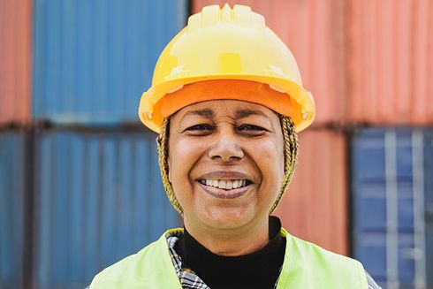 Mujer con casco de seguridad sonriendo. Desarrollo sostenible - Banco Interamericano de Desarrollo - BID 