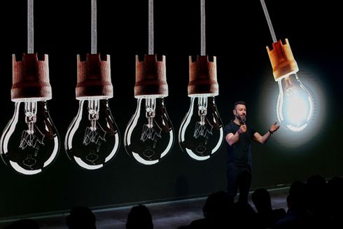 Light bulbs hang from the stage of a presentation