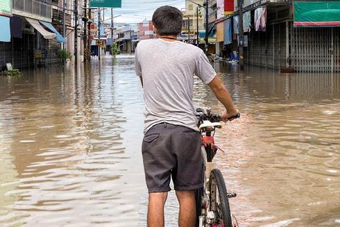 A boy on a bicycle in a flooded street. Environment - Inter-American Development Bank - IDB