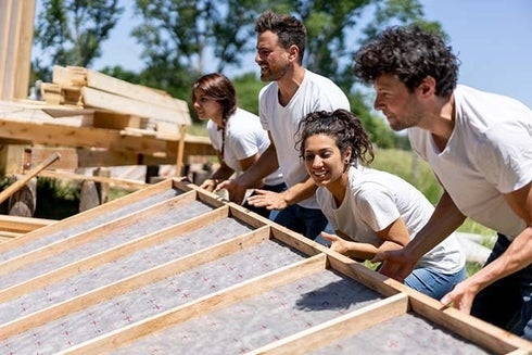 A group of people working on a roof. Investment - Inter-American Development Bank - IDB