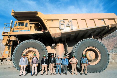 Group of men standing in front of a large truck. Debt Financing - Inter-American Development Bank - IDB