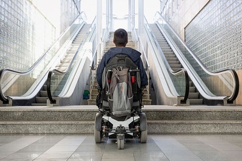 A person sitting in a wheelchair looking at the stairs. Transport - Inter-American Development Bank - IDB
