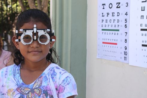 A girl looks forward with optometry glasses while being examined - Inter-American Development Bank - IDB