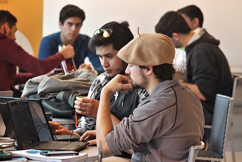 Group of people working in a coworking space with laptops