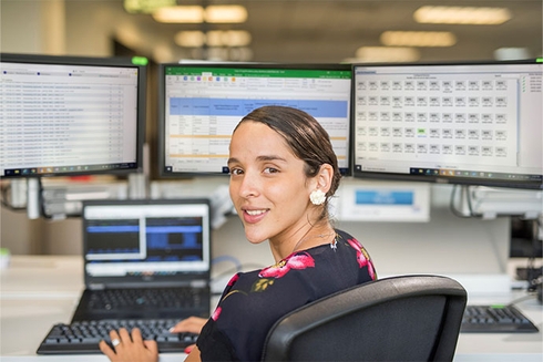 A woman sitting in front of several computer screens