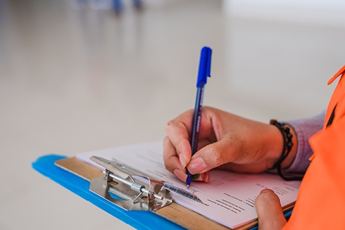 A person writing on a clipboard