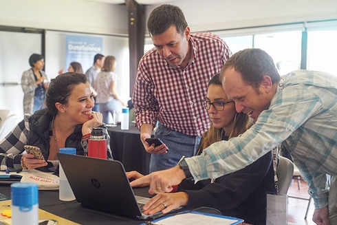 A group of people looking at a laptop