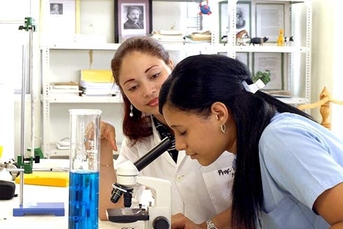 A woman looking through a microscope. Technology and Knowledge - Inter-American Development Bank - IDB