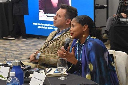 A woman using a microphone sitting next to a man. Public finances - Inter-American Development Bank - IDB