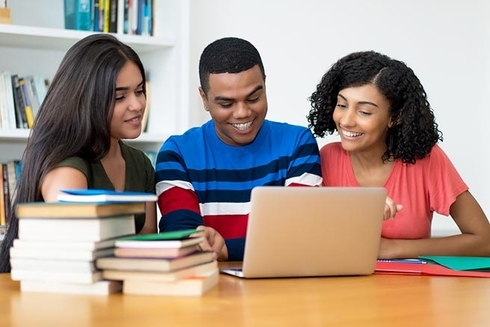 A group of people looking at a laptop. Inclusion - Inter-American Development Bank - IDB