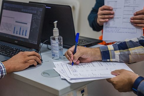 A person filling a form on a desk. Transparency - Inter-American Development Bank - IDB