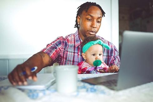 A man and baby looking at a laptop. Wellbeing and Medicine - Inter-American Development Bank - IDB
