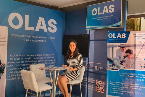 OLAS initiative stand with woman sitting