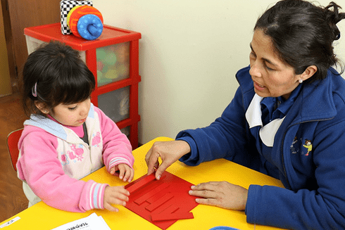 A person and child sitting at a table. Education - Inter-American Development Bank - IDB