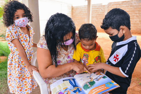 A person reading a book with children. Diversity - Inter-American Development Bank - IDB