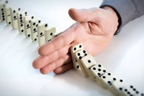 a hand stopping dominoes Sanctions - Inter-American Development Bank - IDB