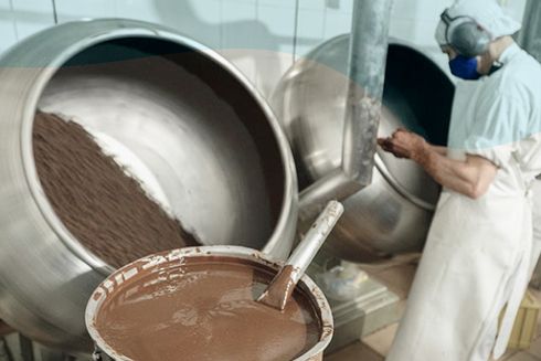 A person mixing chocolate in a large container. IDB