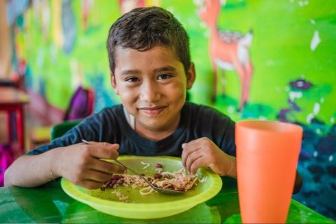 Kid Smiling while eating - Empowering - Inter American Development Bank - IDB