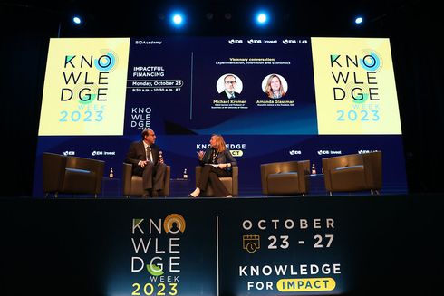 Two speakers participating in a panel discussion on a stage at the Knowledge Week 2023 event - Regional Cooperation - Inter-American Development Bank - IDB