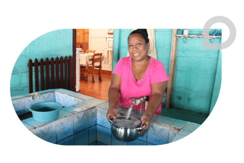 Woman collecting water - Story - Greater Access to Potable Water - Inter American Development Bank - IDB