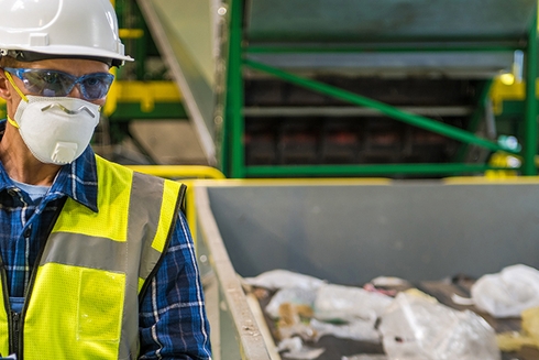 Male worker watching a solid waste machine - Inter American Development Bank - Water and Sanitation