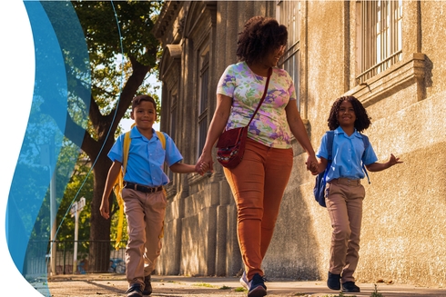 Afro-descendant woman walking with her children down a street - Inter American Development Bank - Impact Framework