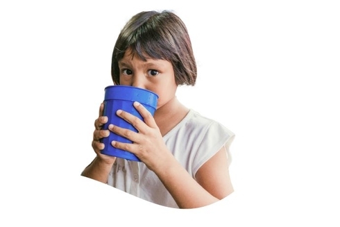 A young girl drinks clean water from a blue glass, highlighting access to safe drinking water.