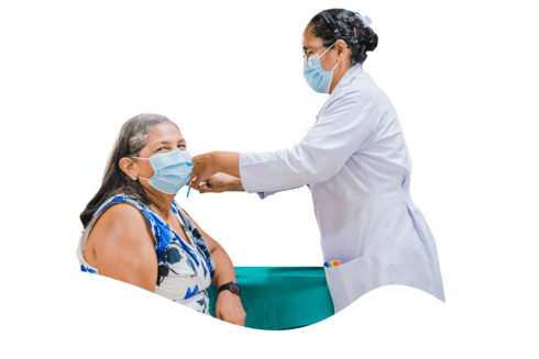 A female doctor helps a patient put on a face mask during a medical consultation - IDB - Inter-American Development Bank - Sustainable Development