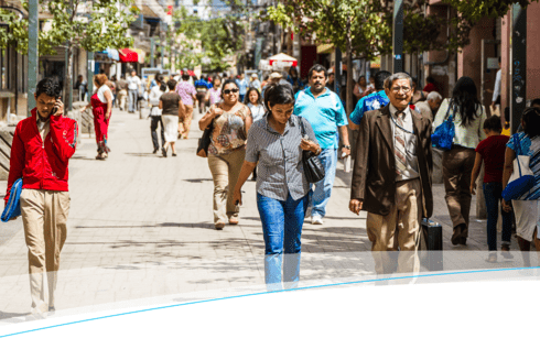 People walking down a wide street in daylight - Inter American Development Bank - Impact Framework