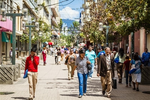People walking down a wide street in daylight - Inter American Development Bank - Impact Framework
