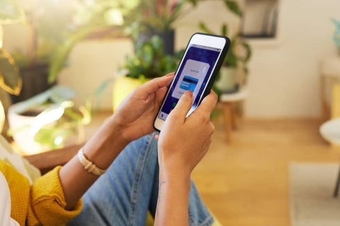 Hands of a person touching a mobile smartphone in a lounge - Inter American Development Bank - Research