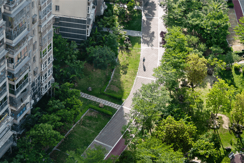 Aerial view of a modern building complex with green spaces, walking paths, and tree-lined park areas - IDB - Inter-American Development Bank 