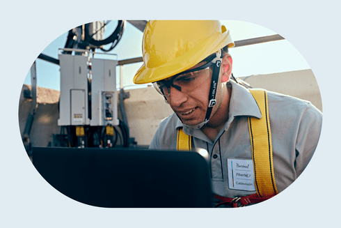 Man wearing a hard hat working in a factory and observing a machine - Inter American Development Bank - Procurement