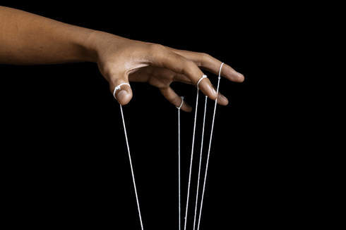 Close-up of a hand holding several ropes in its fingers - Inter American Development Bank - Transparency