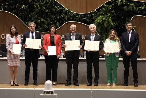 Ian Goldfjan walking with executives holding a certificate - Inter American Development Bank - IDB Energy