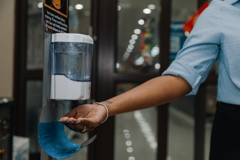 Hand receiving antibacterial gel from a container - Inter American Development Bank - Public Sector