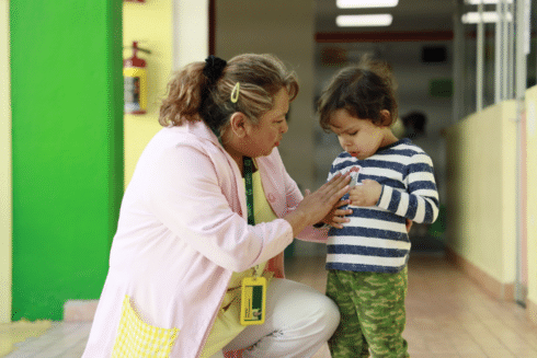Caregiver supporting a young child in an early childhood care setting IDB