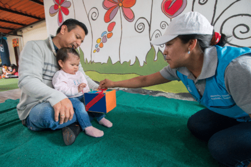 Caregiver assisting an older adult using a walker at home IDB