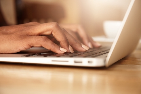 A close-up of a woman's hands typing on a laptop keyboard, with focus on the keys and her fingers - Sustainable Development - Inter-American Development Bank - IDB