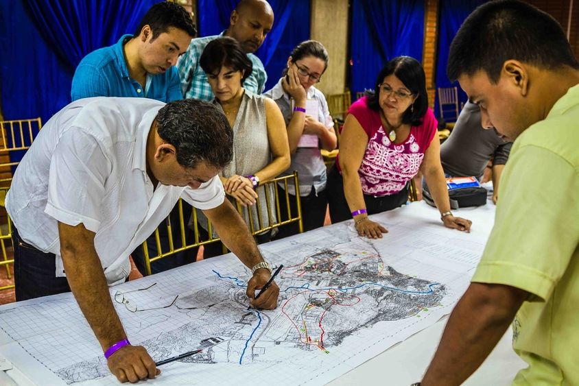 Personas observando un mapa de ordenamiento territorial. Desarrollo Urbano y Vivienda - Banco Interamericano de Desarrollo