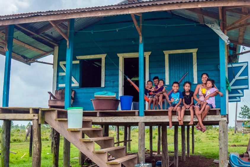 Familia sentada en la entrada de su vivienda en el campo. Medioambiente y equidad - Banco Interamericano de Desarrollo - BID 